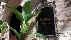 A sign for 'Cincos Sentidos Suites de Lujo' mounted on a brick wall. - 5 Sentidos - Suites de Lujo (Tudela)
