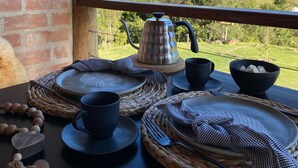 A dining setup with a view of a hilly landscape.
