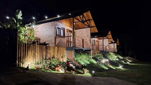 A modern house with a brick exterior, large windows, and a wooden deck.
