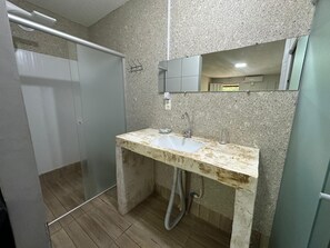 A bathroom with a shower, a sink with a mirror, and a toilet. - PESQUE PAGUE JANGO (Cuiaba)