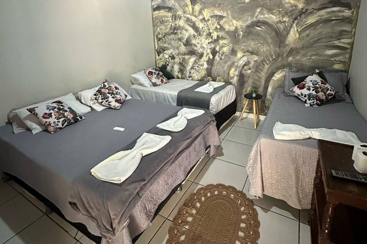 A room with two beds, a small table, and a decorative wall mural.