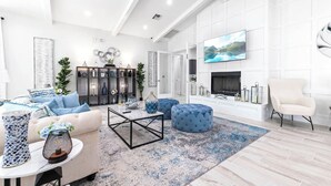 A modern living room with a fireplace, a large TV, and a comfortable seating area.