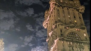 A historic building with ornate architecture, multiple floors, and illuminated windows.