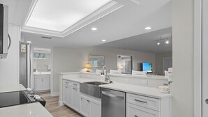 A modern kitchen with white cabinetry, a dishwasher, and a built-in oven.