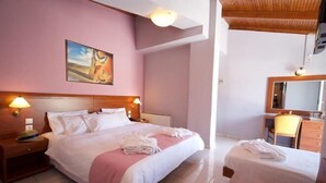 A hotel room with a large bed, bedside tables with lamps, a small desk, and a mirror. - Mirabel CityCenter Hotel (Argostolion)