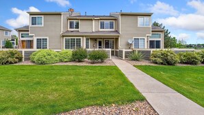 A two-story residential building with a symmetrical facade, multiple windows, and a well-maintained lawn.
