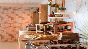 Un bufé con diversos alimentos y una pared decorativa con un diseño geométrico.