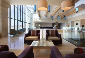 Un hall d’entrée spacieux, doté de hauts plafonds, de grandes fenêtres et d’un mobilier moderne.