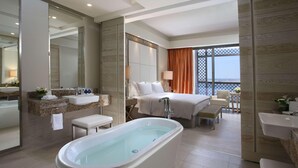 A modern hotel bathroom with a bathtub, a large mirror, a vanity with a sink, and a shower area. - Hilton Dead Sea Resort & Spa (Sweimeh)