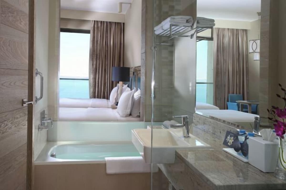 A modern bathroom with a bathtub, a sink, and a shower.