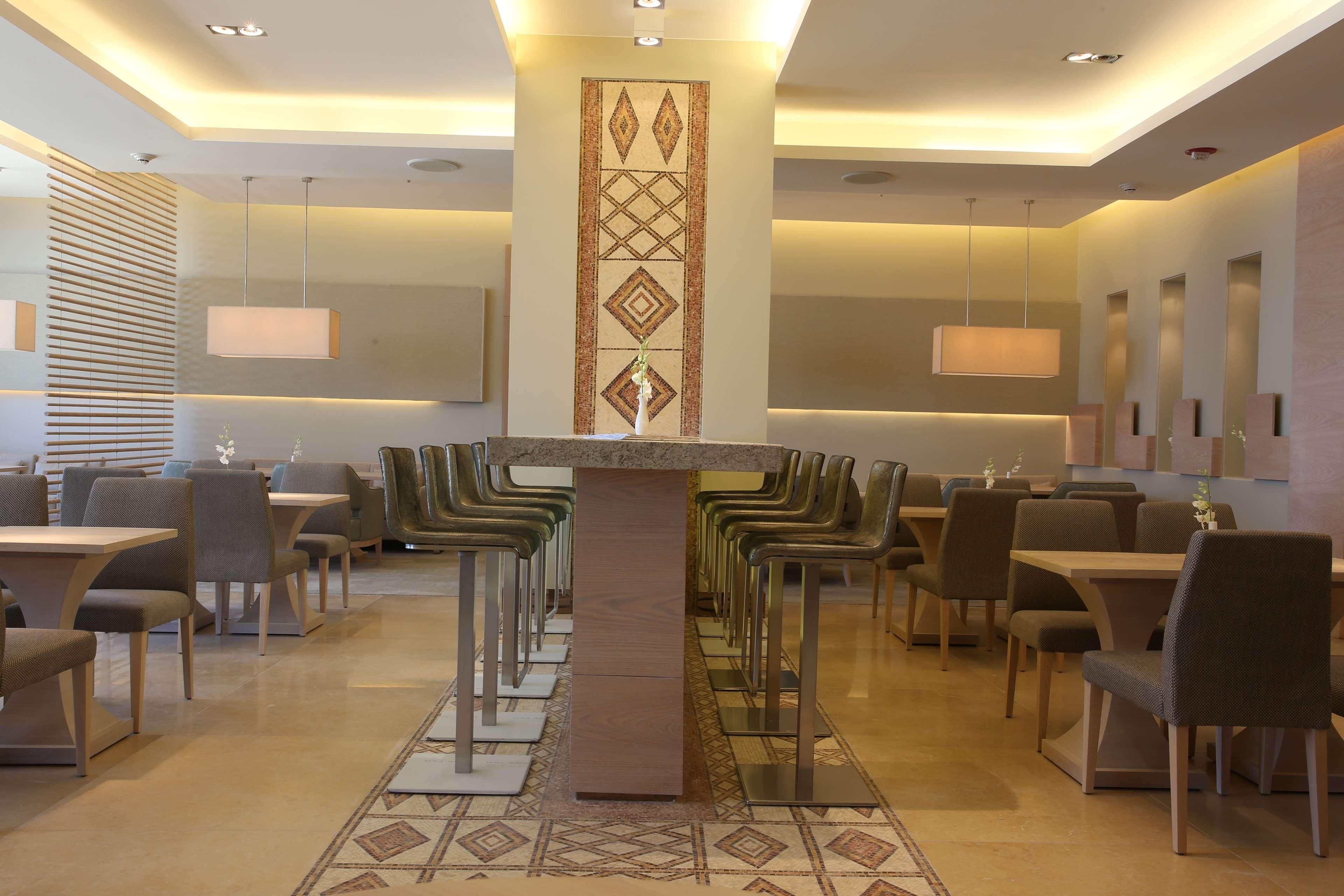 Un comedor moderno con una mesa central, varias sillas e iluminación colgante.