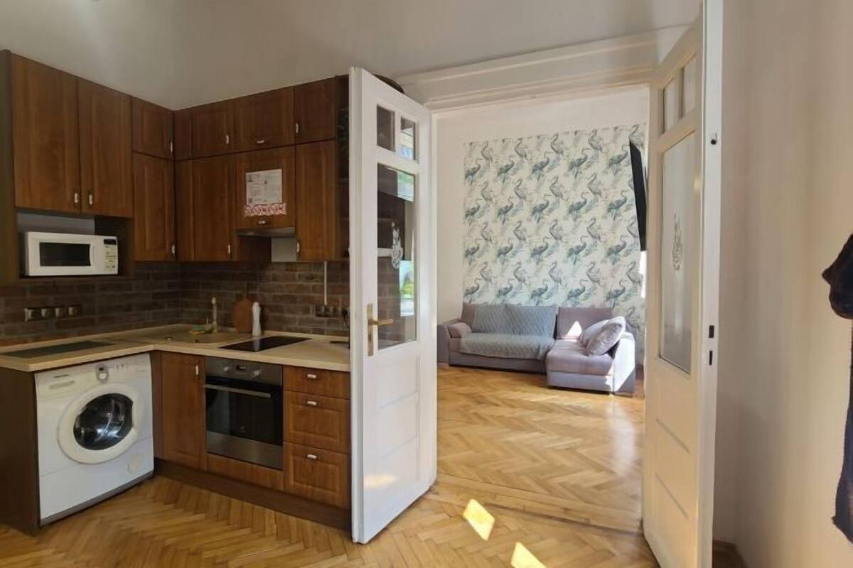 A compact kitchen with a built-in washing machine, a microwave, and a sink.