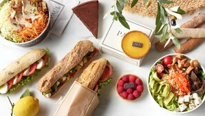 A variety of food items including sandwiches, a quiche, and a salad, arranged on a table.