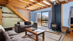 A cozy living room with a sofa, a coffee table, and a fireplace.
