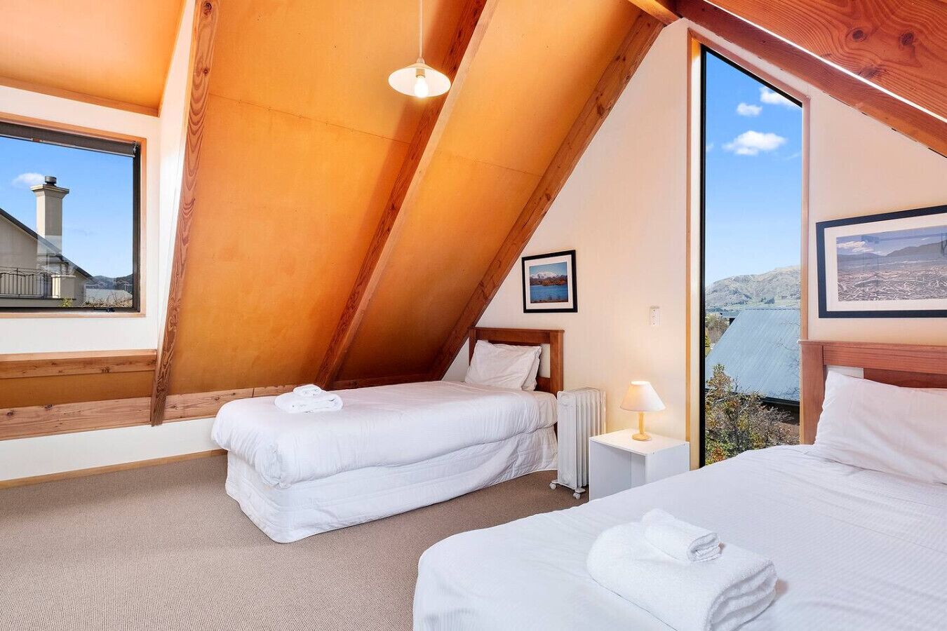 Ein Schlafzimmer mit zwei Betten, einem Fenster, einer Heizung und einem Bild an der Wand.