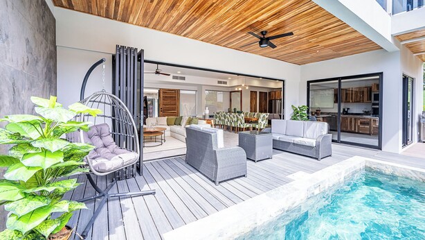 A modern outdoor living area with a pool, wooden deck, and outdoor furniture. - Casa Rio Mar Luxury Villas: The Ultimate Double Escape! 2 Luxury Villas 14 BR/BA (Jaco)