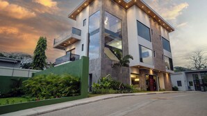 A modern two-story house with a balcony, large windows, and a well-maintained garden. - Casa Rio Mar Luxury Villas: The Ultimate Double Escape! 2 Luxury Villas 14 BR/BA (Jaco)