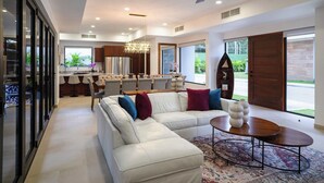 A spacious living room with a white sectional sofa, a round coffee table, and a chandelier. - Casa Rio Mar Luxury Villas: The Ultimate Double Escape! 2 Luxury Villas 14 BR/BA (Jaco)