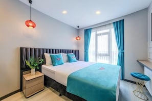 Un dormitorio moderno con cama, mesitas de noche, lámpara colgante y una ventana con cortinas.