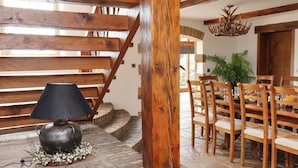 Una escalera de madera con una lámpara y una mesa de comedor con sillas.