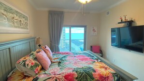 A bedroom with a bed, a ceiling fan, a TV, and a window with a view. - Crystal Towers 609, Corner Unit
Your Perfect Beach Getaway Awaits You! (Gulf Shores)