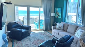 A living room with a sofa, a black leather chair, a TV, and a balcony with a view of the ocean. - Crystal Towers 609, Corner Unit
Your Perfect Beach Getaway Awaits You! (Gulf Shores)