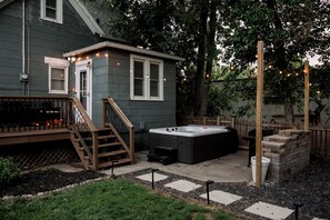 A backyard with a hot tub, wooden deck, and a small house. - FarnamFieldhouse+HotTub+EpicGameRoom+FirePit+Mural (Omaha)