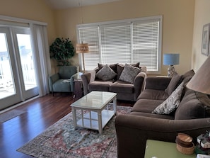 A living room with a sofa, armchair, coffee table, and a potted plant. - Islander Villa Condo / Oceanfront Views! Sleeps 12 By Williamson Realty (Ocean Isle Beach)