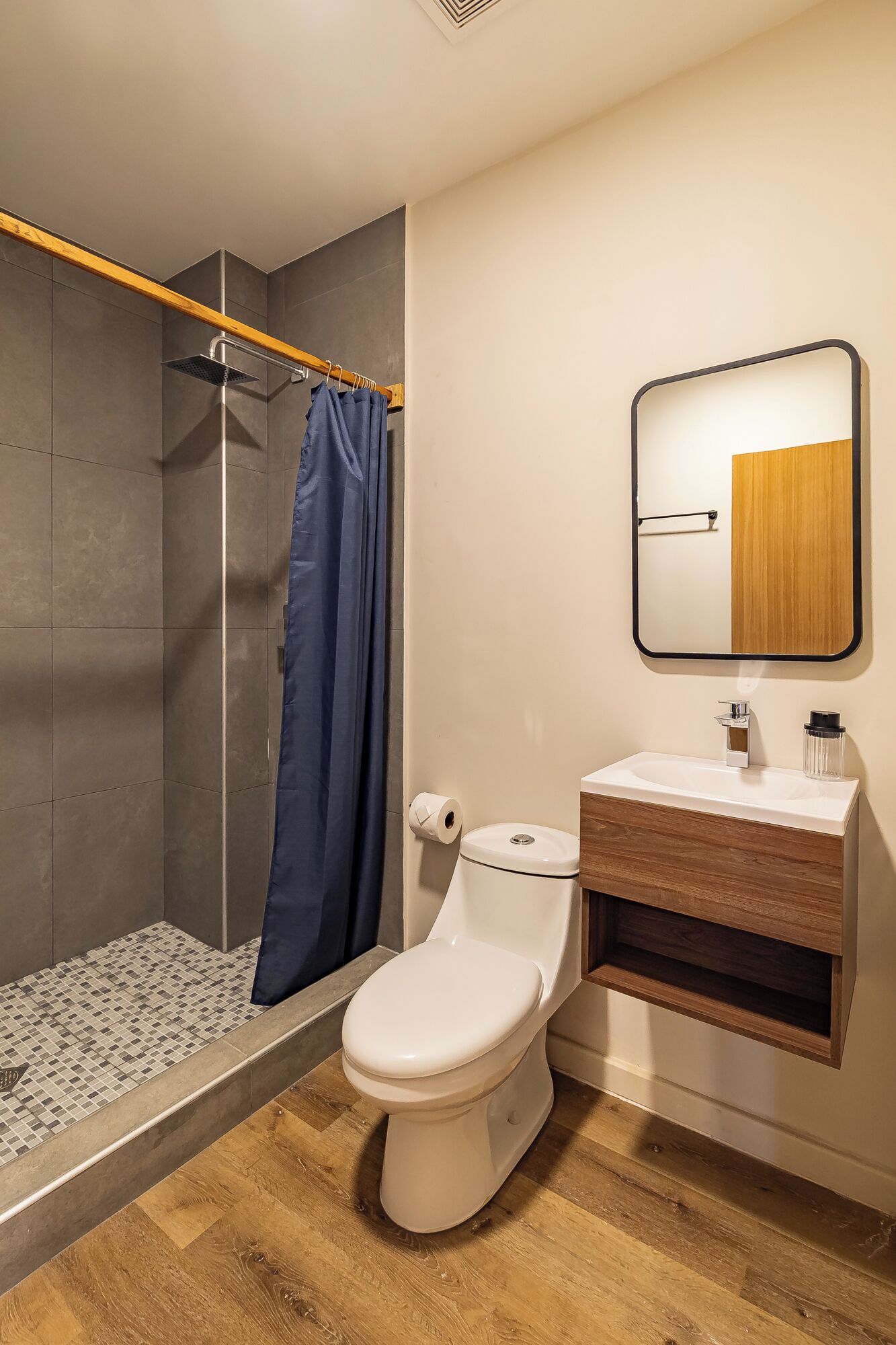 Un baño moderno con ducha, inodoro y lavamanos.