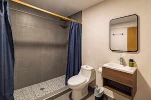 Un baño moderno con ducha, inodoro y lavamanos.