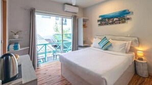 Une chambre d’hôtel avec un lit, un ventilateur de plafond, un appareil de climatisation, une vue sur le balcon extérieur et un tableau au mur.