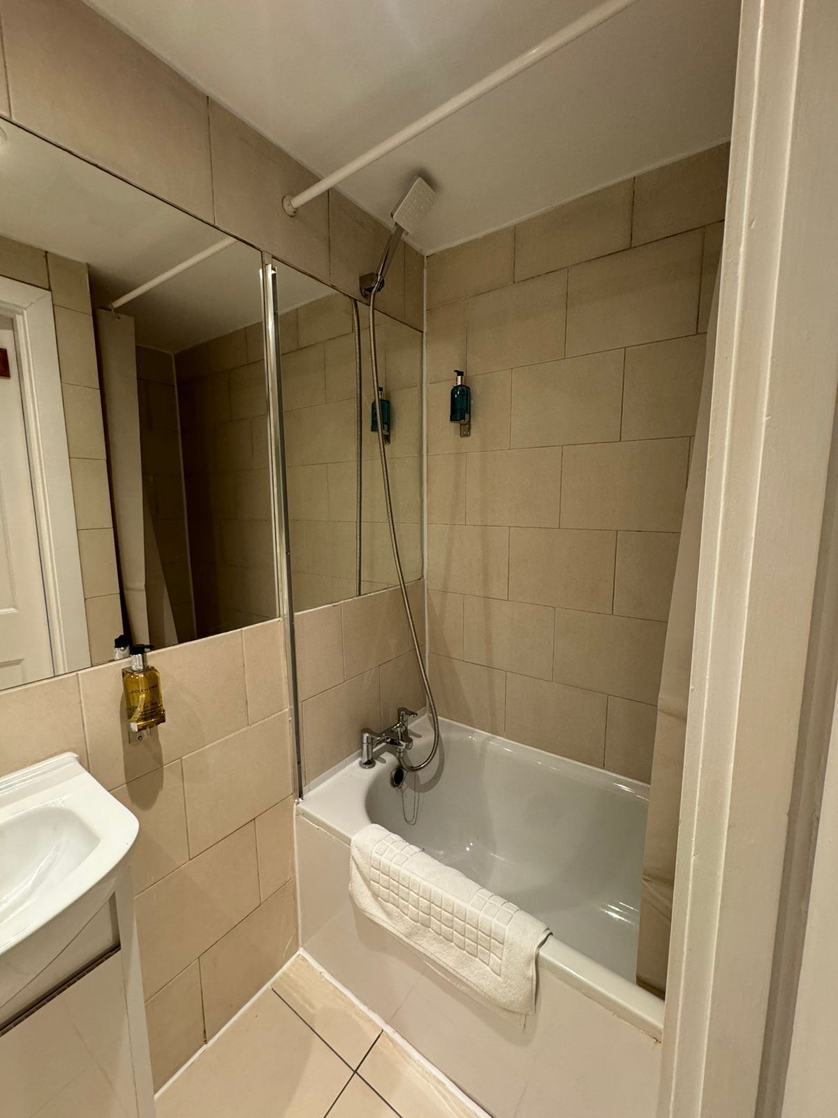 A modern bathroom with a bathtub, a shower, and a sink.