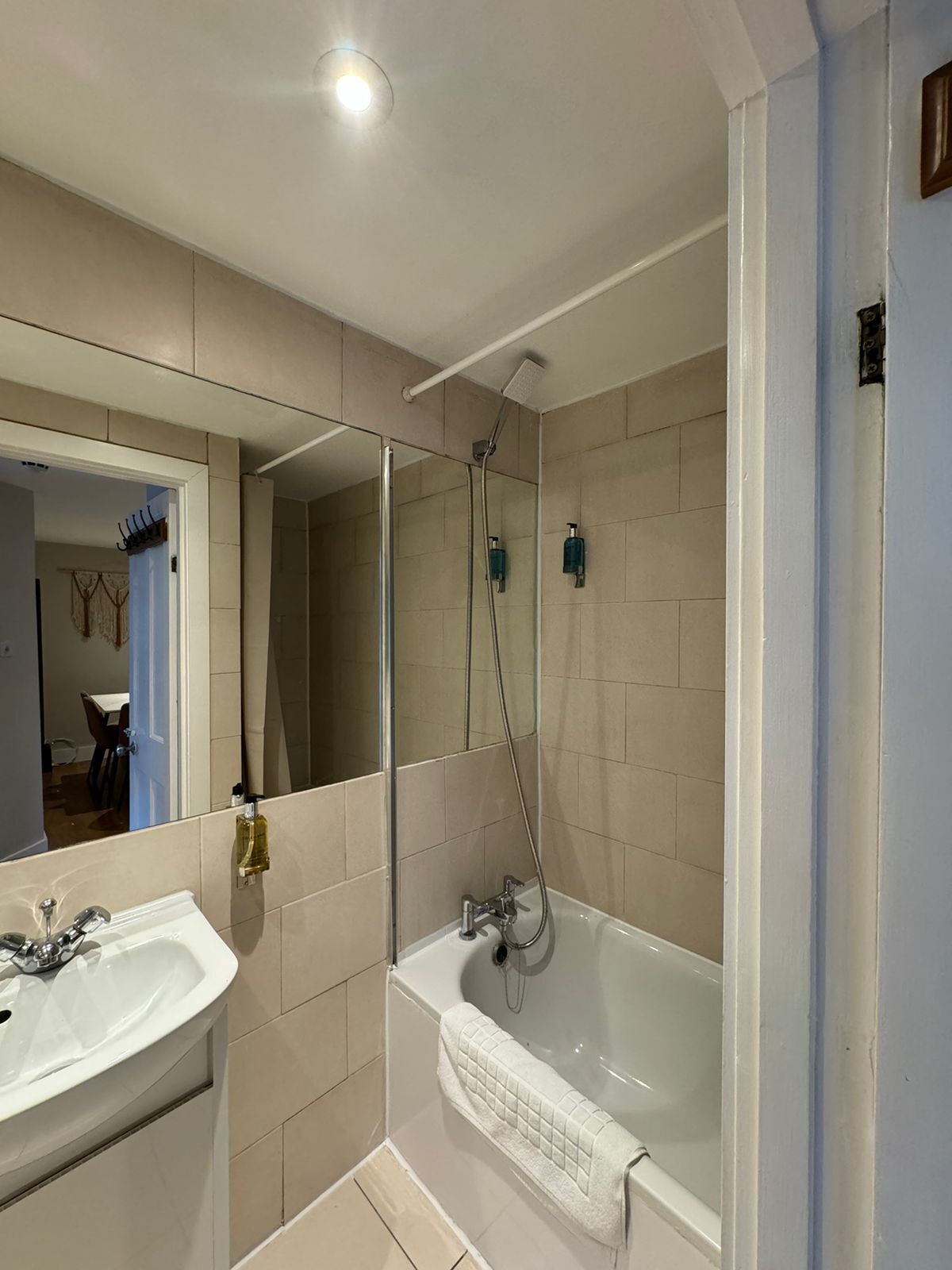 A modern bathroom with a sink, mirror, shower, and bathtub.