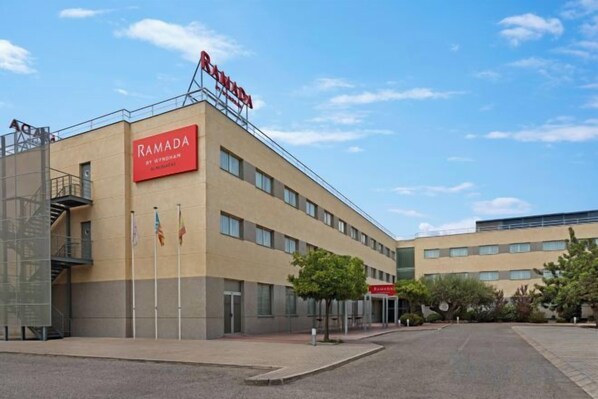 Un edificio con un cartello che indica 'RAMADA' e 'PARCHEGGIO', segnalando una struttura per il parcheggio.