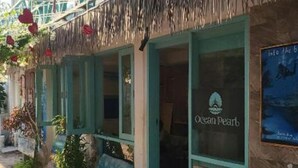 A coastal building with a sign reading "Ocean Pearl." - Ocean Pearl : Deluxe Double Room with balcony (Maafushi)