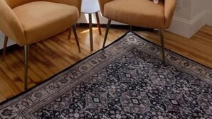 Une pièce comprenant deux fauteuils, une petite table et un tapis à motifs.