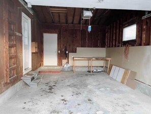 Una stanza con pareti in legno, una porta, un tavolo e una finestra.