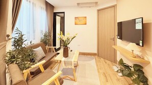Una sala de estar moderna con sofá, mesa de centro y televisor montado en la pared.