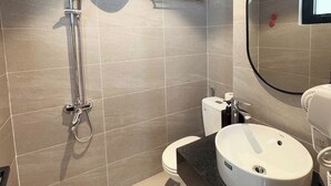 Un baño moderno con ducha, inodoro y lavamanos.