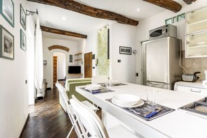 A modern kitchen with a central island, white cabinetry, and a stainless steel refrigerator. - GuestHost - Cosy 50 sqm flat with balcony, sleeping up to 3 people, located on the 2nd floor of a period building (NO lift).The apartment is located in the picturesque village of Marola, a seaside hamlet of La Spezia. The hamlet is well connected to the  (La Spezia)