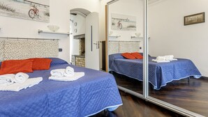Habitación de hotel con dos camas, un espejo grande y obras de arte en las paredes.