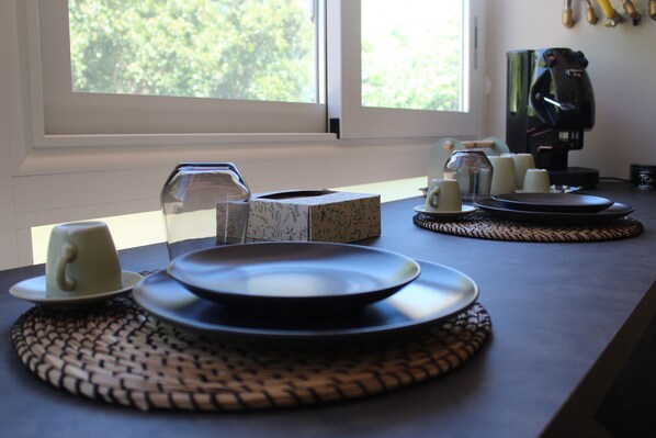 A dining table set with plates, a cup, and a box of tissues.