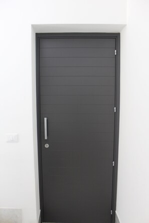 A black door with a silver handle and a keyhole, set in a white wall. - Villa Mercurio 1st Floor 600 meters from the beautiful beach of MONDELLO (Palermo)