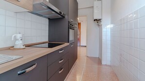 A modern kitchen with a wooden countertop, dark cabinets, a stainless steel range hood, and a white tiled backsplash. - GuestHost - Cozy and bright 80 sqm apartment, perfect for 5 people, located on the second floor of a building with a lift.Located in the heart of the Ligurian Riviera, the property is located in Rapallo, in a convenient and well-served area. The location (Rapallo)