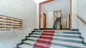 A staircase with a red carpet, marble steps, and a wooden handrail. - GuestHost - Cozy and bright 80 sqm apartment, perfect for 5 people, located on the second floor of a building with a lift.Located in the heart of the Ligurian Riviera, the property is located in Rapallo, in a convenient and well-served area. The location (Rapallo)