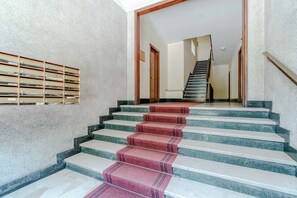 A staircase with a red carpet, marble steps, and a wooden handrail. - GuestHost - Cozy and bright 80 sqm apartment, perfect for 5 people, located on the second floor of a building with a lift.Located in the heart of the Ligurian Riviera, the property is located in Rapallo, in a convenient and well-served area. The location (Rapallo)
