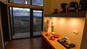 Una cocina moderna con un amplio ventanal, una mesa de madera y varios electrodomésticos.