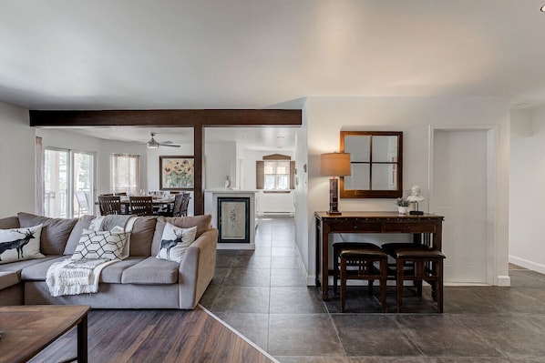 A spacious living room with a sofa, coffee table, and a dining area with a table and chairs.