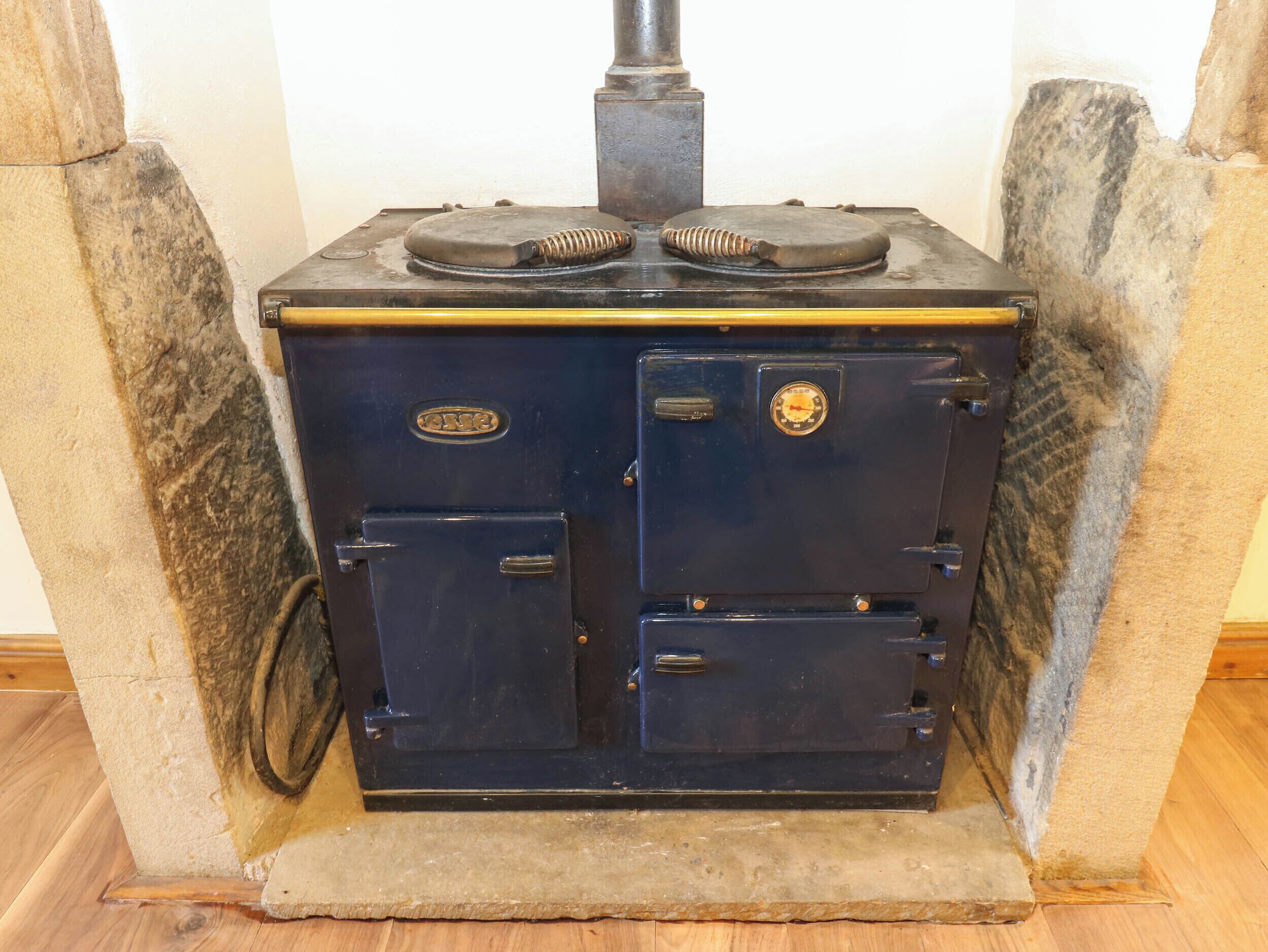A vintage stove with two doors and a chimney.