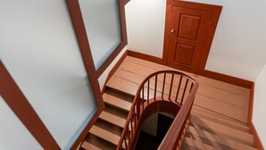 Un escalier en bois, doté d’une rampe, mène à une porte située en haut.